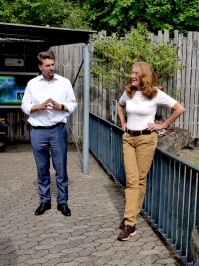 Umweltministerin Petra Berg und Oberbürgermeister Uwe Conradt stehen vor dem Gehege der Humboldtpinguine.
